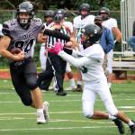 Wallace Adams keeps a Colony High School defender at arms length during a Huskies home game. Adams was named first team all-conference on both sides of the ball as well as all-conference kicker. (Ben Hohenstatt / Juneau Empire File)