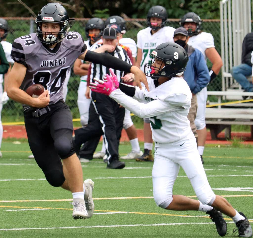 Wallace Adams keeps a Colony High School defender at arms length during a Huskies home game. Adams was named first team all-conference on both sides of the ball as well as all-conference kicker. (Ben Hohenstatt / Juneau Empire File)