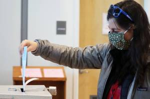 Sarah Traiger drops off a ballot at the Mendenhall Valley Public Library vote center on Tuesday, the last day to cast a ballot in the City and Borough of Juneaus 2021 municipal election. (Ben Hohenstatt / Juneau Empire)