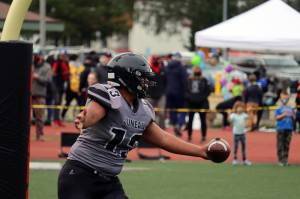 Sam Sika, a junior who plays full back and defensive line for the Huskies, celebrates after scoring a touchdown against South Anchorage High School. (Ben Hohenstatt / Juneau Empire)