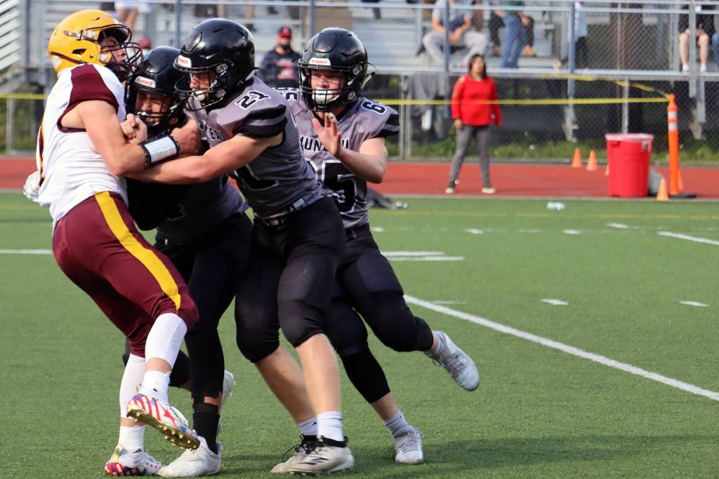 A trio of Huskies bring down a Dimond Lynx. Juneau prided itself on playing swarming defense. Defensive huddles broke on the word swarm during practice. (Ben Hohenstatt / Juneau Empire)