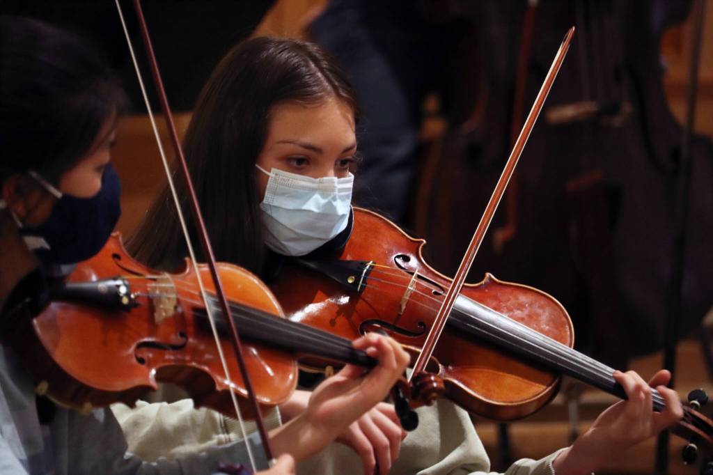 Angela Haffer (right) and Jin Yue Trousil play violin during rehearsal for the Juneau Symphonys upcoming performance. (Ben Hohenstatt / Juneau Empire)
