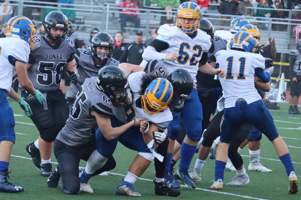 Brandon Campbell (65), and Sage Richards (57), both junior defensive lineman, wrap up Bartlett running back Aleva Lilomaiava. (Ben Hohenstatt / Juneau Empire)