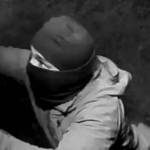 This screen capture from surveillance footage released by the Anchorage Police Department shows a masked man vandalizing the Alaska Jewish Museum in Anchorage in May. (Courtesy photo / APD)