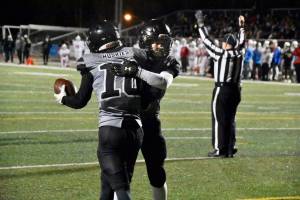 James Connally (10), a senior, and Payton Grant, a junior, embrace following a touchdown. Connally caught and threw for a touchdown in the Huskies 30-17 loss to Bettye Davis East Anchorage High School. (Courtesy Photo / Larry Schrader)