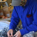 Charles Maier fills goodie bags at the Kenai Senior Center on Friday, Oct. 22, 2021 for next weekends drive-through trick-or-treat event. (Camille Botello/Peninsula Clarion)
