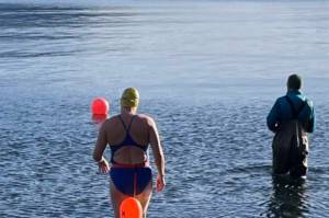 Cheryl Fellman enters the chilly waters of Auke Bay. Freeman is on the verge of becoming one of only 43 Americans  and 422 people worldwide  to swim an official Ice Mile. (Courtesy photo/Cheryl Fellman)