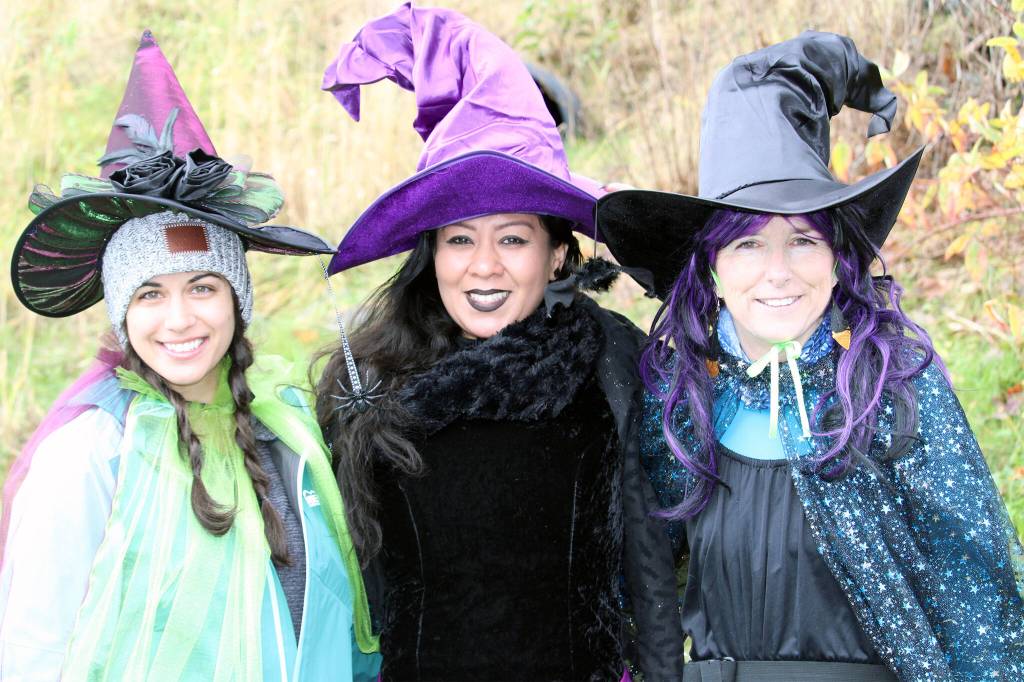 Kira Shollenberger, left, Marisol Elizarraras, center, and Bev OBrien, right, prepare to enter the chilly waters of the Auke Lake on Saturday, Oct. 30 as part of a Witches Paddle. OBrien, who helped organize the event, said she hopes the event grows in the future  possibly becoming a fundraiser. (Dana Zigmund/Juneau Empire)