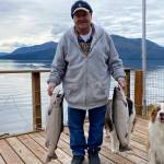 Oscar and Kéet inspect the fresh cohos caught by Mickey Prescott. (Vivian Faith Prescott / For the Capital City Weekly)