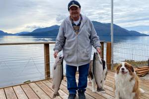 Oscar and Kéet inspect the fresh cohos caught by Mickey Prescott. (Vivian Faith Prescott / For the Capital City Weekly)