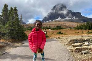 In this photo provided by Ben Pascal, five-year-old Naomi Pascal, holding her teddy bear, is pictured on a hike to Hidden Lake in Glacier National Park, Mont., in October 2020. Naomi lost the bear while on the hike, but it was found by a park ranger who took care of the bear until it was spotted on the dash of his ranger truck and returned to Naomi this fall. (Ben Pascal)