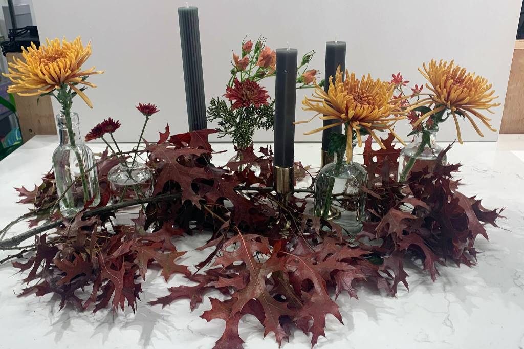 Dana Zigmund/Juneau Empire 
This picture shows an arrangement of candles, eclectic vases and seasonal botanicals created by Frenchies Floral Studio. According to the shops co-owner, Jeremy Bauer, spreading several elements out across the table is a low-cost way to create a Thanksgiving tablescape.