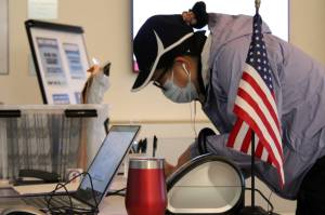 In this Empire file photo, Juneau citizen Mary Ellen Yadao signs her name to vote in the City and Borough of Juneau Municipal Election on Oct. 6, 2020. Speaking to a panel of cybersecurity experts Thursday, Lt. Gov. Kevin Meyer said the state is taking advantage of federal resources to bolster election security. (Ben Hohenstatt / Juneau Empire file)
