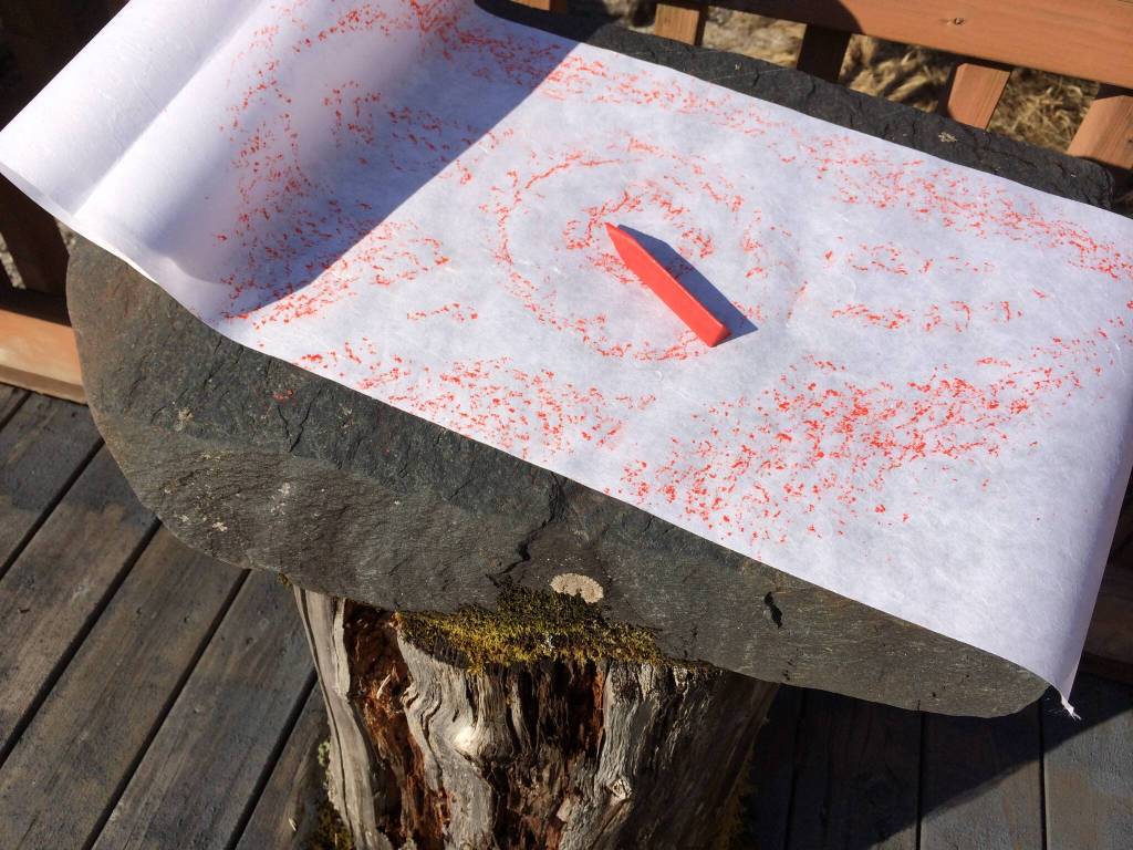 Making a rubbing from a replica at Petroglyph Beach State Historic Site. Making a rubbing from original glyphs is illegal. (Vivian Faith Prescott / For the Capital City Weekly)