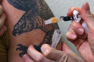 Public Health nurse April Rezendes gives a Juneau resident their flu vaccine at the Juneau Public Health Center on Nov. 23, 2021. The vaccine is available as are COVID-19 vaccinations. (Ben Hohenstatt / Juneau Empire)