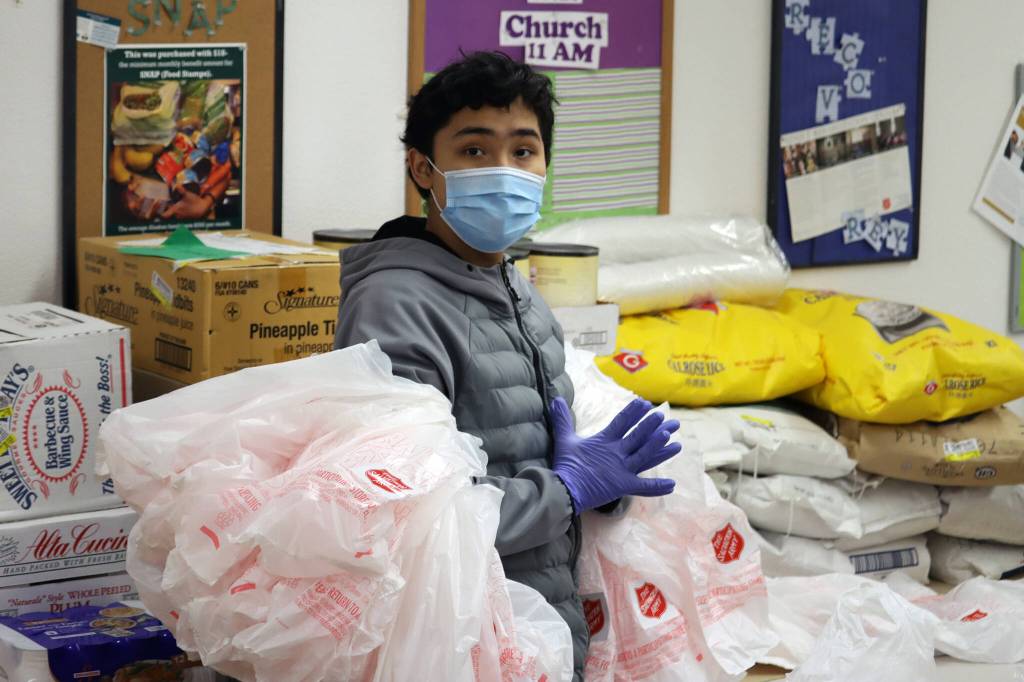Benami Bean has plenty of bags at the ready while preparing meals for distribution on Thursday. (Ben Hohenstatt / Juneau Empire)