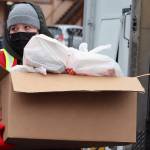 Meagan Bryd, an AmeriCorps volunteer, carries a box load of meals toward a vehicle for delivery on Thanksgiving. (Ben Hohenstatt Juneau Empire)