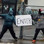 Abbey Greer and Kelsey Rich show drivers the way in to the Salvation Armys meal distribution site on Thursday. (Ben Hohenstatt / Juneau Empire)
