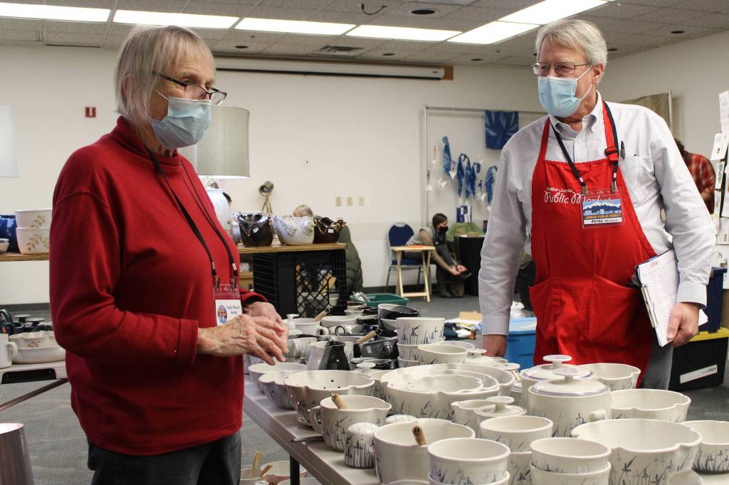 Betty Bell and Peter Metcalfe, longtime Juneau Public Market organizer, chat Friday before the market opened. (Dana Zigmund / Juneau Empire)