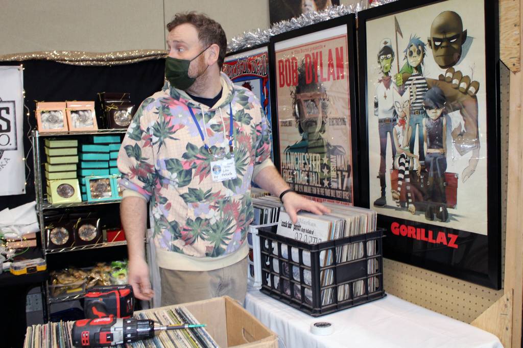 Luke Metcalfe sets up his record shop at Juneau Public Market on Friday, Nov. 26. (Dana Zigmund / Juneau Empire)