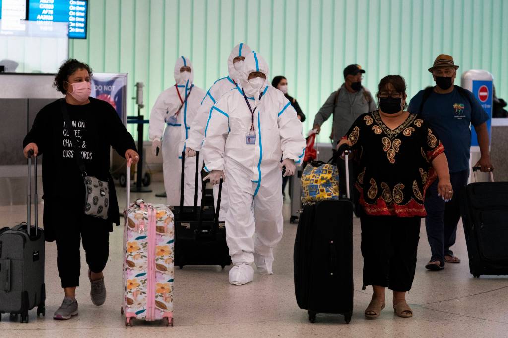 AP Photo / Jae C. Hong
Air China flight crew members in hazmat suits walk through the arrivals area Tuesday at Los Angeles International Airport. The U.S. on Wednesday reported its first case of the omicron variant.
