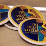 Buttons boasting of fully vaccinated status sit on a counter top at Juneau Public Health Center. (Ben Hohenstatt / Juneau Empire)
