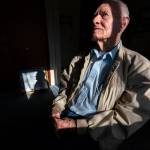 Pearl Harbor survivor and World War II Navy veteran David Russell, 101, poses for a photo along with a painting of the USS Oklahoma at his home on Monday, Nov. 22, 2021, in Albany, Ore. (AP Photo / Nathan Howard)