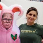 Sam Adams, stands with a holiday decoration at the Mendenhall Mall on Nov. 24. Since 2014, she has volunteered her time to set up a collection that includes thousands of miniature, holiday-themed buildings complete with small, festive figurines in a locally donated space. (Dana Zigmund/Juneau Empire)