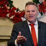 Gov. Mike Dunleavy spoke with reporters at the Alaska Governor's Mansion on Tuesday, Dec. 7, 2021, before greeting guests for the traditional Christmas open house. The event was suspended last year due to COVID-19 but was back this year with limited health mitigation rules in place. (Peter Segall / Juneau Empire)