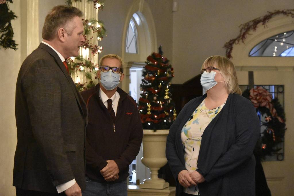 Gov. Mike Dunleavy, left, meets with City and Borough of Juneau Mayor Beth Weldon, right, and City Manager Rorie Watt, center, at a Christmas open house event at the Alaska Governors Mansion on Dec. 7, 2021. (Peter Segall / Juneau Empire)
