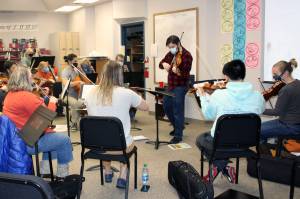 Franz Felkl, concertmaster and artistic director for the Juneau Symphony, leads a rehearsal at Juneau-Douglas High School: Yadaa.at Kalé on Dec. 7. (Dana Zigmund/Juneau Empire)