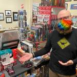 Alaska Robotics Gallery co-owner Aaron Suring gestures at Sushi Go!, one of a number of games locally obtainable and ideal for gifting this holiday season. (Michael S. Lockett / Juneau Empire)