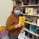 Brenda Weaver, owner of Hearthside Books and Toys, holds up the most recent book by Heather Lende, recently chosen as the Alaska State Writer Lauereate. (Michael S. Lockett / Juneau Empire)