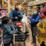 Alaska State Trooper Chris Umbs and Victoria Larson talk to Ethan and Wilbur during the annual Shop with a Cop Event at Fred Meyer on Dec. 18, 2021. (Michael S. Lockett / Juneau Empire)