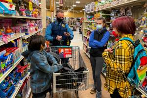 Alaska State Trooper Chris Umbs and Victoria Larson talk to Ethan and Wilbur during the annual Shop with a Cop Event at Fred Meyer on Dec. 18, 2021. (Michael S. Lockett / Juneau Empire)