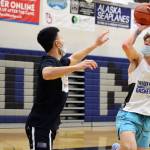 Thomas Baxter, a sophomore, rises for a shot over Bryson Echiverri, a former TMHS standout, during practice. Echiverri, who currently plays for Spokane Community College, was back in the capital city for the holidays and the Thunder Mountain High School alumni game. (Ben Hohenstatt / Juneau Empire)