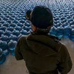Dan Martinez, emergency manager for the Confederated Tribes of Warm Springs, pauses in a classroom used to store donated water on Tuesday, Dec. 7, 2021, in, Warm Springs, Ore. In Oregon, tribal officials have handed out about 3 million gallons (11 million liters) of water  almost all of it donated  from a decommissioned elementary school on the reservation. (AP Photo / Nathan Howard)