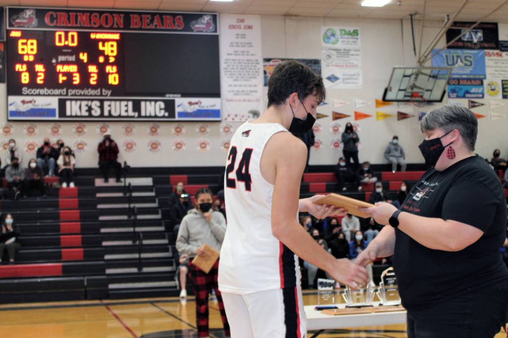 Juneau-Douglas High School: Yadaa.at Kalé junior Kai Hargrave collects his plaque from softball coach Lexie Razor after being named the boys free-throw champ at the Princess Tours Capital City Classic on Dec. 30. (Dana Zigmund/Juneau Empire)