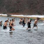 Participants rush back to shore following the 2022 Polar Dip on Saturday. Dozens showed up despite heavy snow. (Ben Hohenstatt / Juneau Empire)