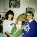 This photo was taken at the The Sámi Reindeer People exhibit, 2004, Alaska Native Heritage Center. Sheri Biddle (left) and son in Sara family cradle, and (right) mother, Lois Stover, Kodiak, Alaska (Descendant of Sara, Twitchell, Kvamme Sámi herders).(Courtesy Photo /Nathan Muus)