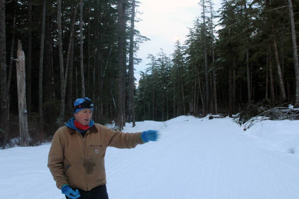 Wayne Carnes looks over the wear and tear from the prior days skiers and walkers on Pioneer Road on Jan. 18. (Dana Zigmund/Juneau Empire)