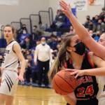 JDHS Mila Hargrave pivots toward the hoop for a tough inside shot while tightly defended by TMHS Sydney Strong. In the background JDHS Kiyara Miller and TMHS Kerra Baxter look on. (Ben Hohenstatt / Juneau Empire)