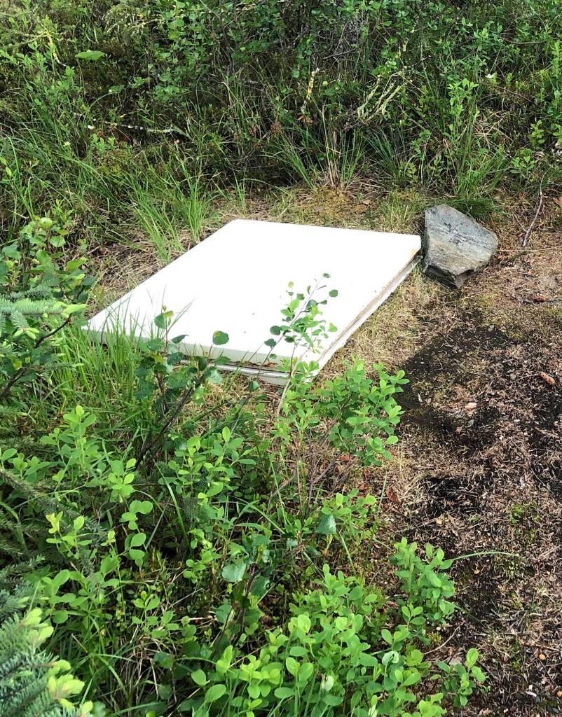 The top of a freezer John Gaedeke sank into permafrost ground at his lodge in the Brooks Range. Warmish permafrost surrounding the freezer keeps the temperature stable enough that beers left inside for the entire frigid winter do not freeze. (Courtesy Photo / Alice Bailey)