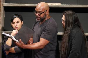 Max (Mike Rao), Felix (Eddie Jones) and Visarut (Phai Giron) consult a book containing information that attempts to rationalize an apparent uptick in sightings of Asian-looking ghosts. (Ben Hohenstatt / Juneau Empire)