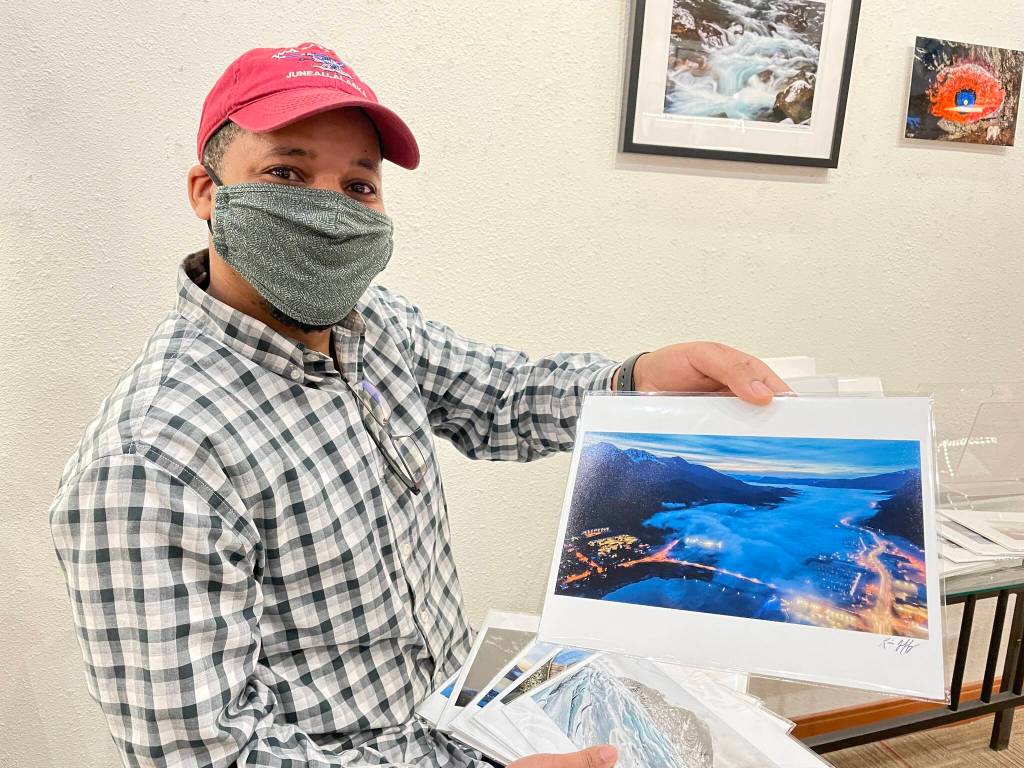 Kevin Jeffrey, one of Annie Kaills featured artists for the March First Friday event, holds a shot from his photography series New Perspectives, shot in Juneau using a drone. (Michael S. Lockett / Juneau Empire)