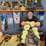 Dallas Seavey is shown Feb. 22, 2022, posing with his five Iditarod Trail Sled Dog championship trophies in Talkeetna, Alaska. Seavey is tied with musher Rick Swenson for the most Iditarod victories ever at five, and Seavey is looking for his sixth title when the Iditarod Trail Sled Dog Race starts this weekend in Alaska. (AP Photo / Mark Thiessen)