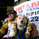 Iditarod winner Brent Sass poses for photos with lead dogs Morello, left, and Slater in the finish chute of the Iditarod Trail Sled Dog Race in Nome, Alaska, Tuesday March 15, 2022. (Anne Raup / Anchorage Daily News)