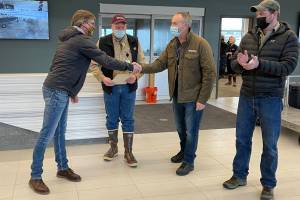 Alaska Seaplanes co-owner Kent Craford, center right, shakes hands with Gary Stears, a principle maintenance inspector for the Federal Aviation Administration as Seaplanes joins the FAAs Safety Management System program in a ceremony at Juneau International Airport on March 15, 2022. (Michael S. Lockett / Juneau Empire)