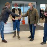 Alaska Seaplanes co-owner Kent Craford, center right, shakes hands with Gary Stears, a principle maintenance inspector for the Federal Aviation Administration as Seaplanes joins the FAAs Safety Management System program in a ceremony at Juneau International Airport on March 15, 2022. (Michael S. Lockett / Juneau Empire)