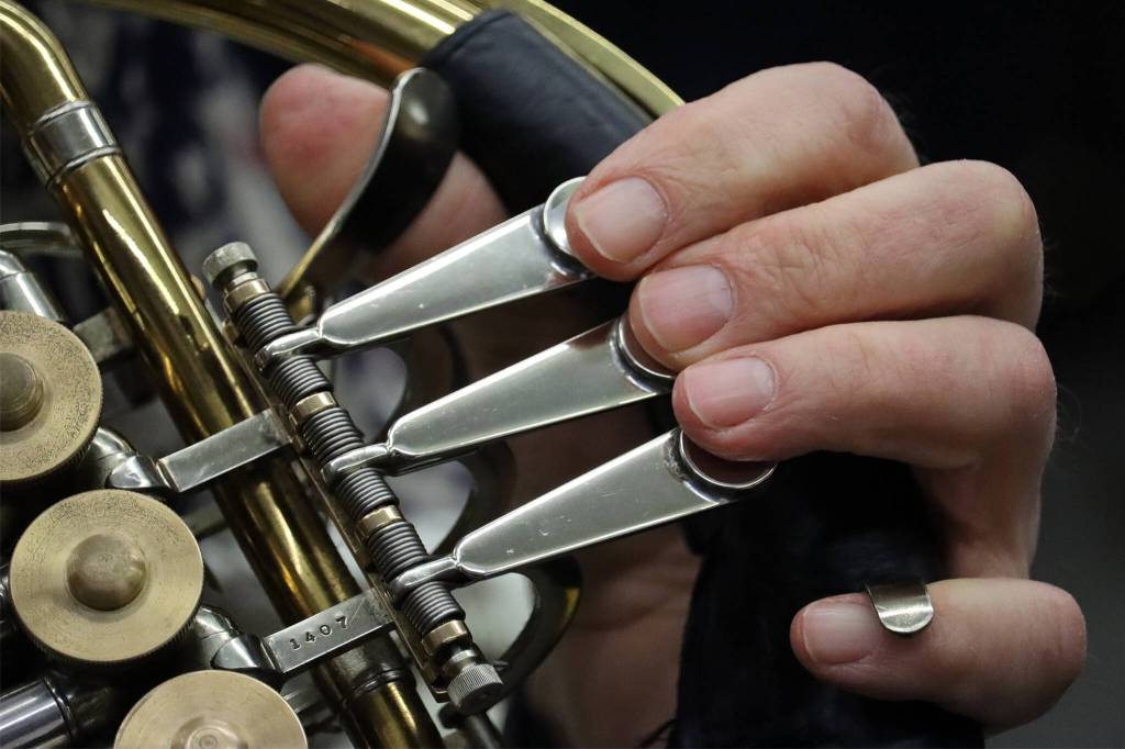 Bill Paulick places his fingers on his horns key levers during rehearsal for an upcoming Horns a Plenty concert. (Ben Hohenstat / Juneau Empire)